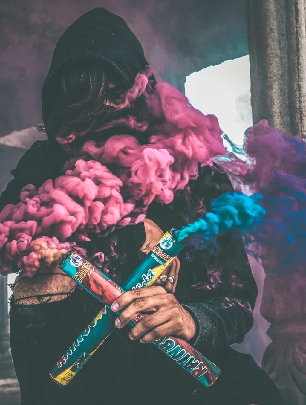 A Boy in Hood With Colorful Smoke