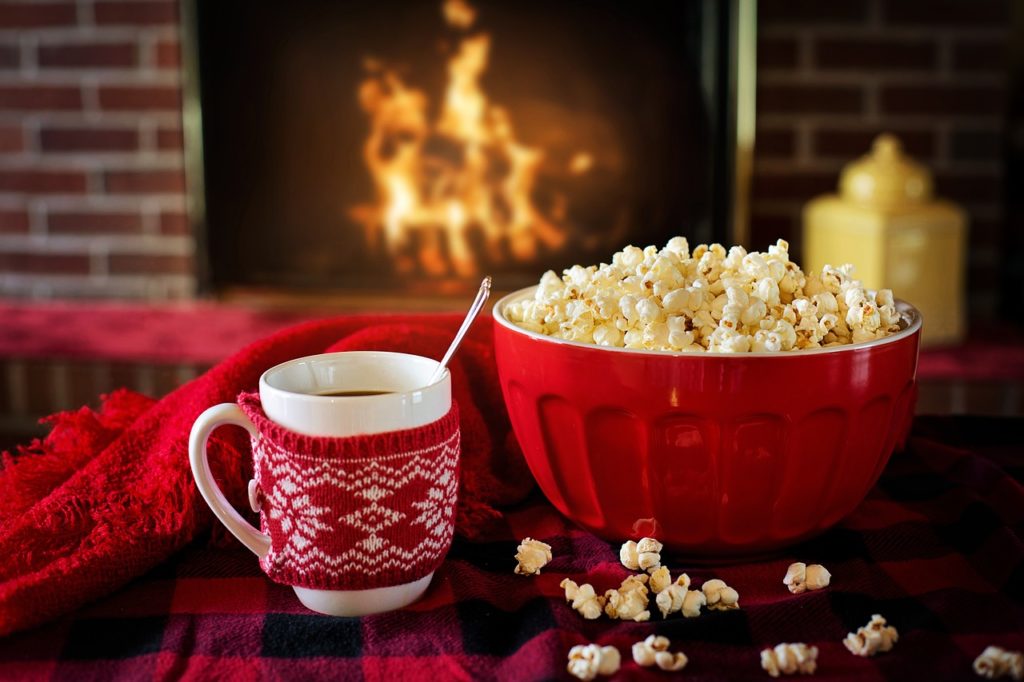 Popcorn and cocoa overlooking a cozy, crackling fireplace