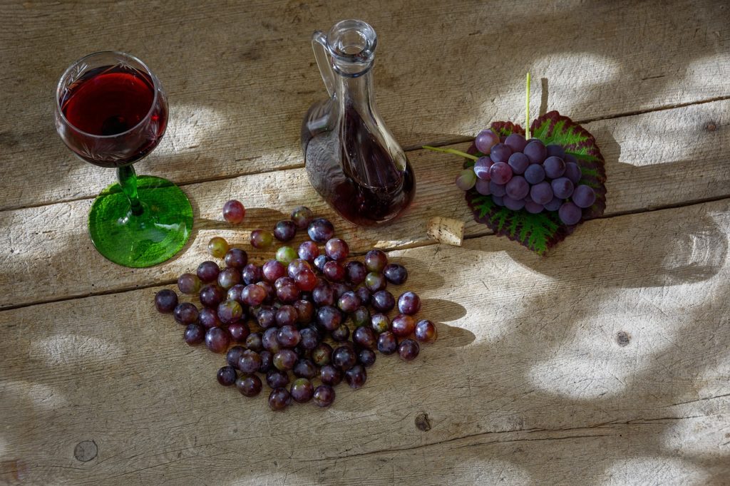wine and grapes on a rustic wooden surface