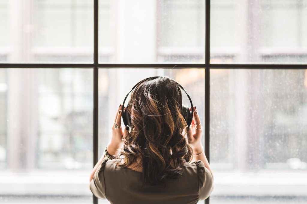 Woman listening to headphones looking out the window